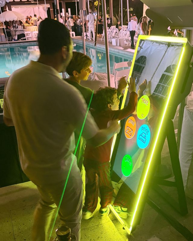 Guests sharing their photos instantly at the interactive mirror during a poolside simcha
